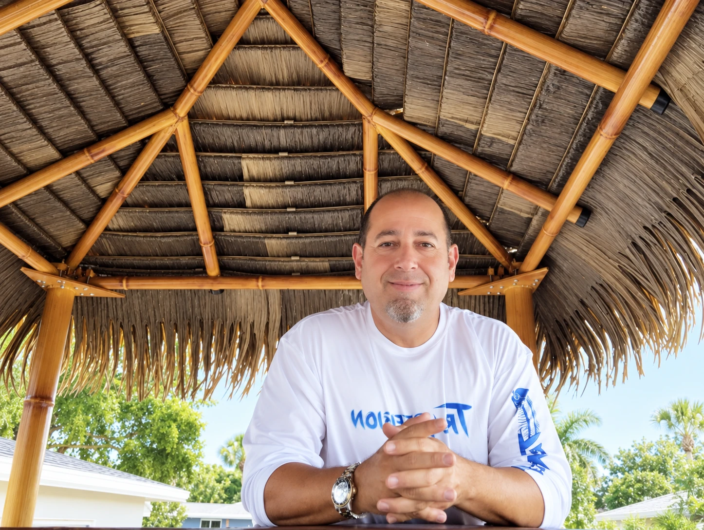 Dan the Tiki Man beneath a thatched tiki hut